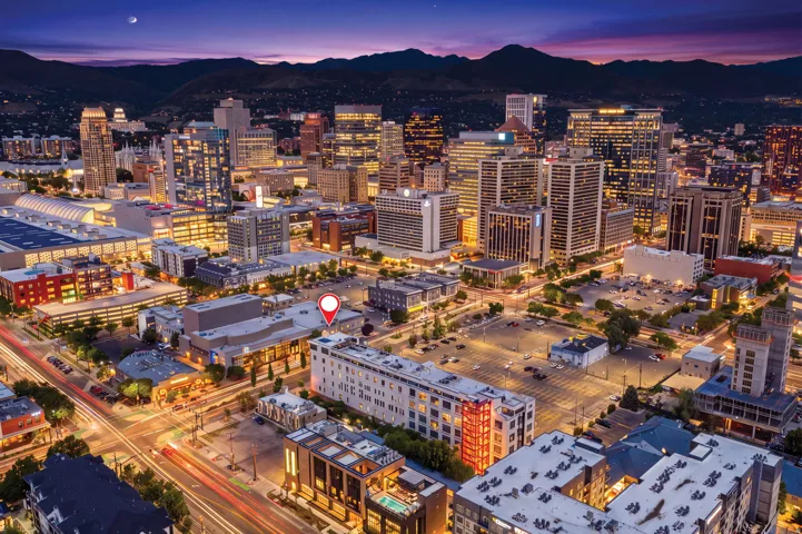 Urban landscape with illuminated buildings and surrounding mountains