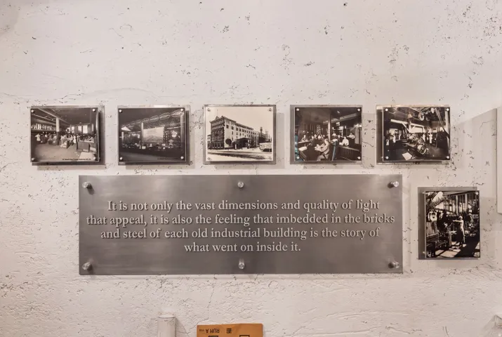 Textured wall featuring a large metallic plaque with engraved text