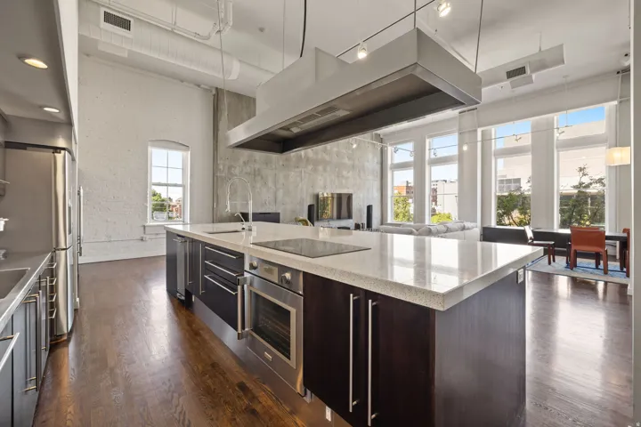 Gourmet kitchen featuring a large island with integrated cooktop, stainless steel appliances, and sleek cabinetry