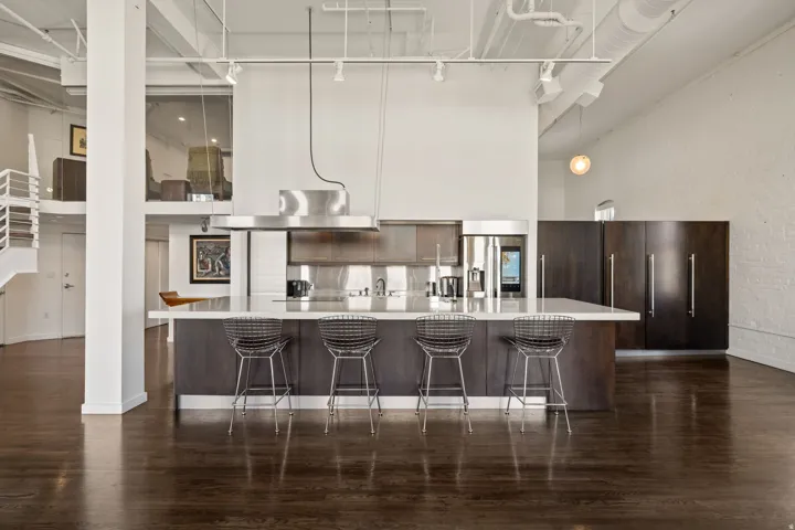 Kitchen island with a light-toned countertop and integrated stainless steel sink