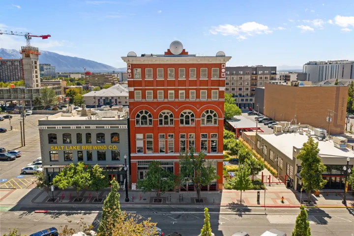 Multi-story brick building featuring arched windows, cornice detailing, and a prominent rooftop architectural element