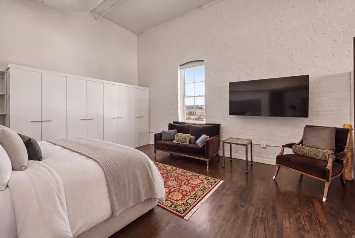 Wood-finish flooring with white brick wall accent