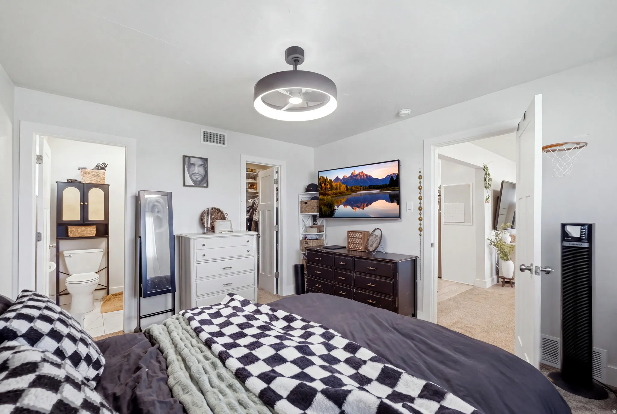 White walls with a ceiling-mounted light fixture, carpeted flooring, and a white interior door
