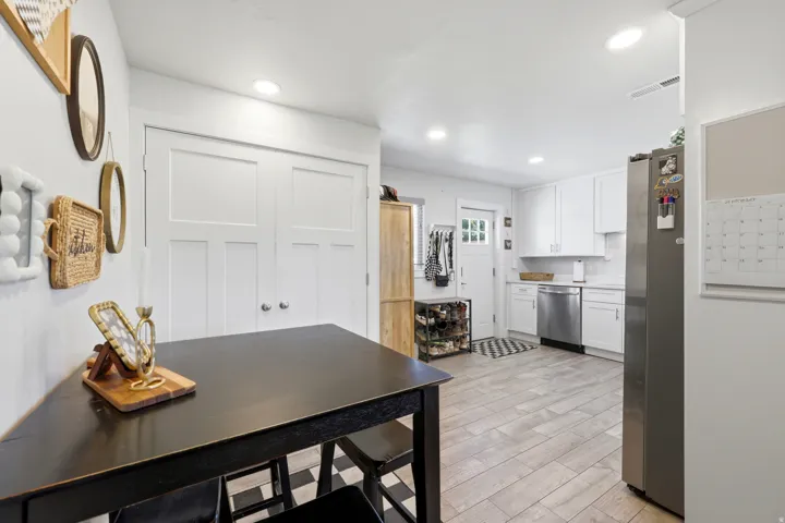 White shaker cabinetry with stainless steel appliances, light wood-finish flooring, and recessed ceiling lighting