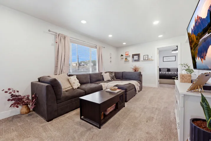 Recessed lighting, light-toned carpeting, window with blinds, and white interior walls