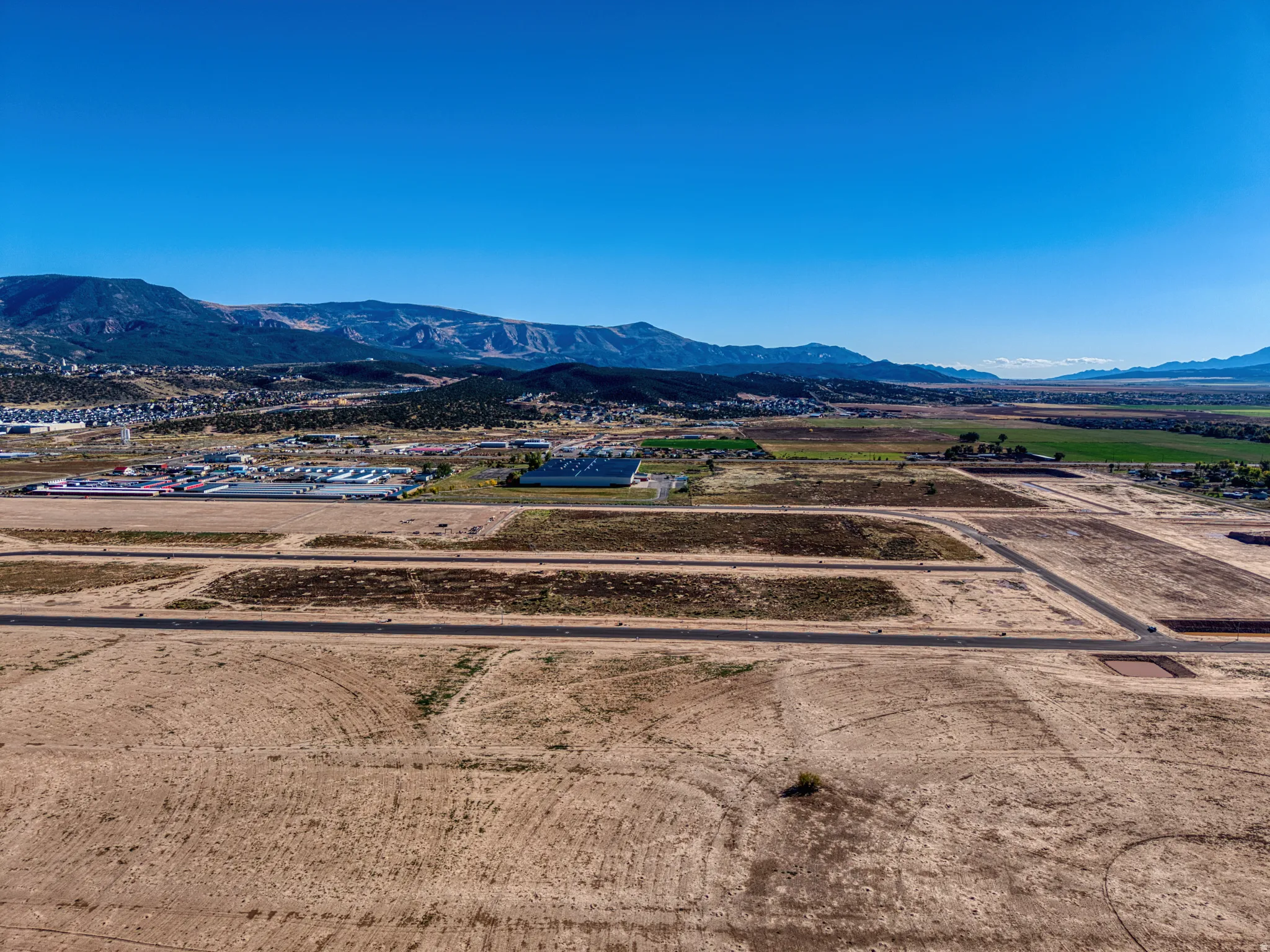 Expansive land parcel with graded roads and mountain backdrop