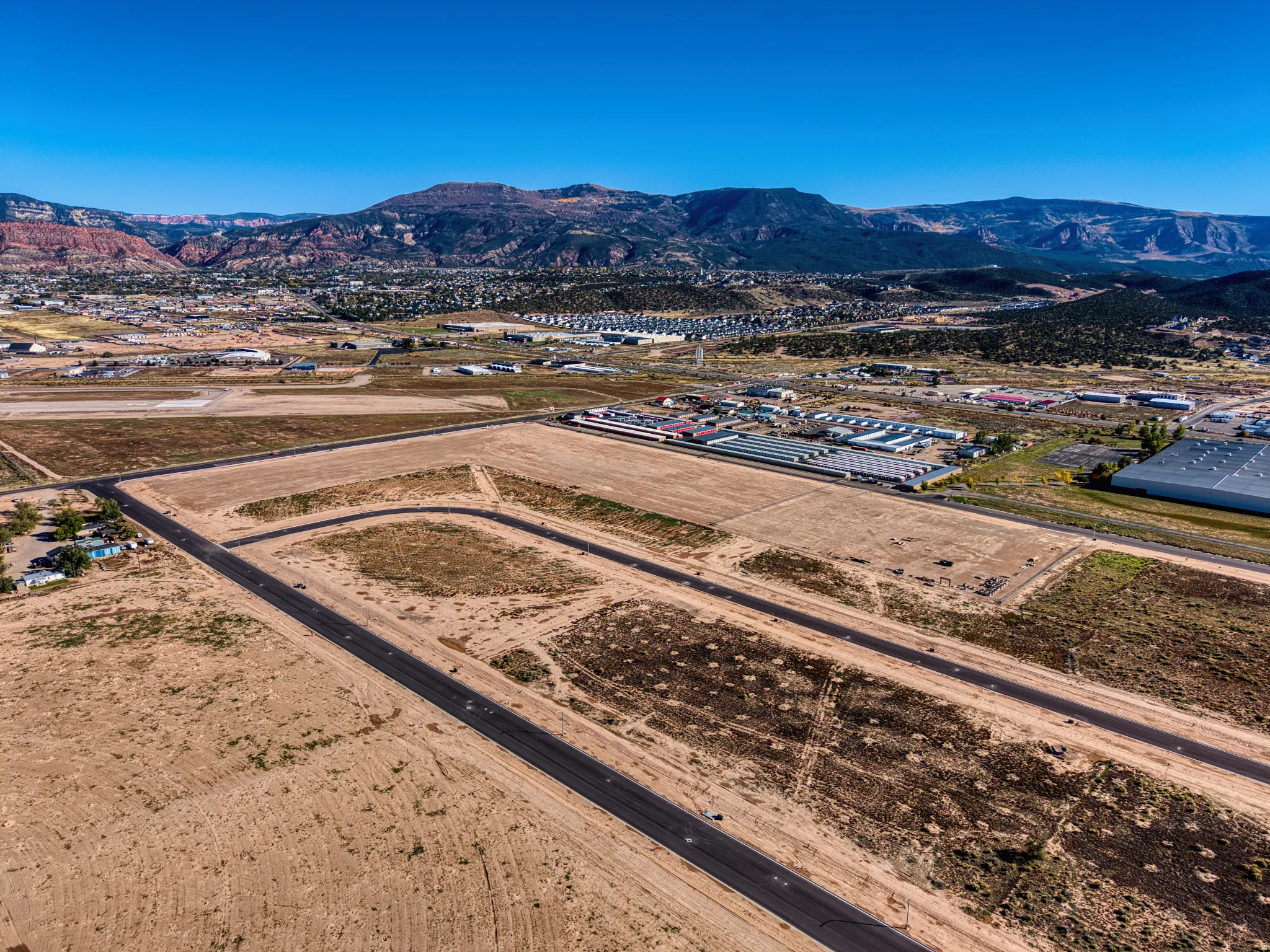 Expansive undeveloped land with visible roads and mountainous scenery
