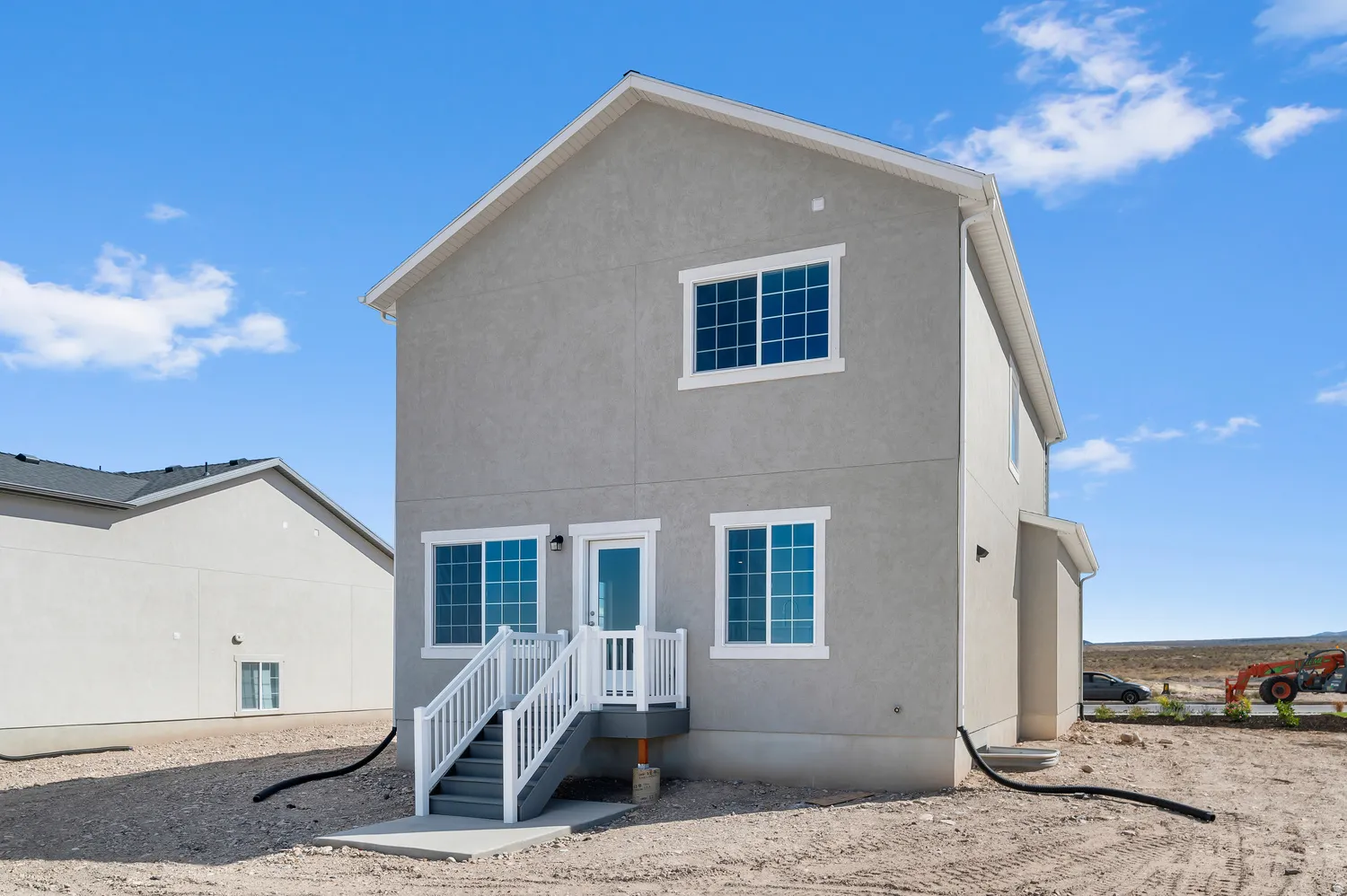 Stucco exterior with white trim windows and a rear entry door