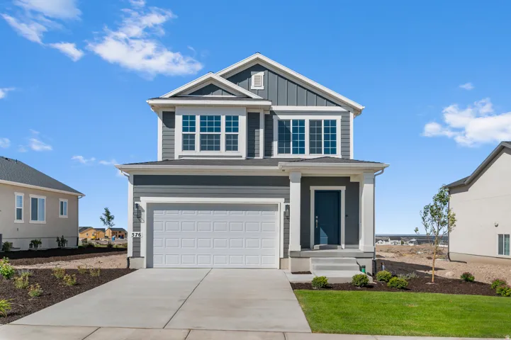 Two-story residence featuring a gray exterior, white trim, and a prominent front porch with columns