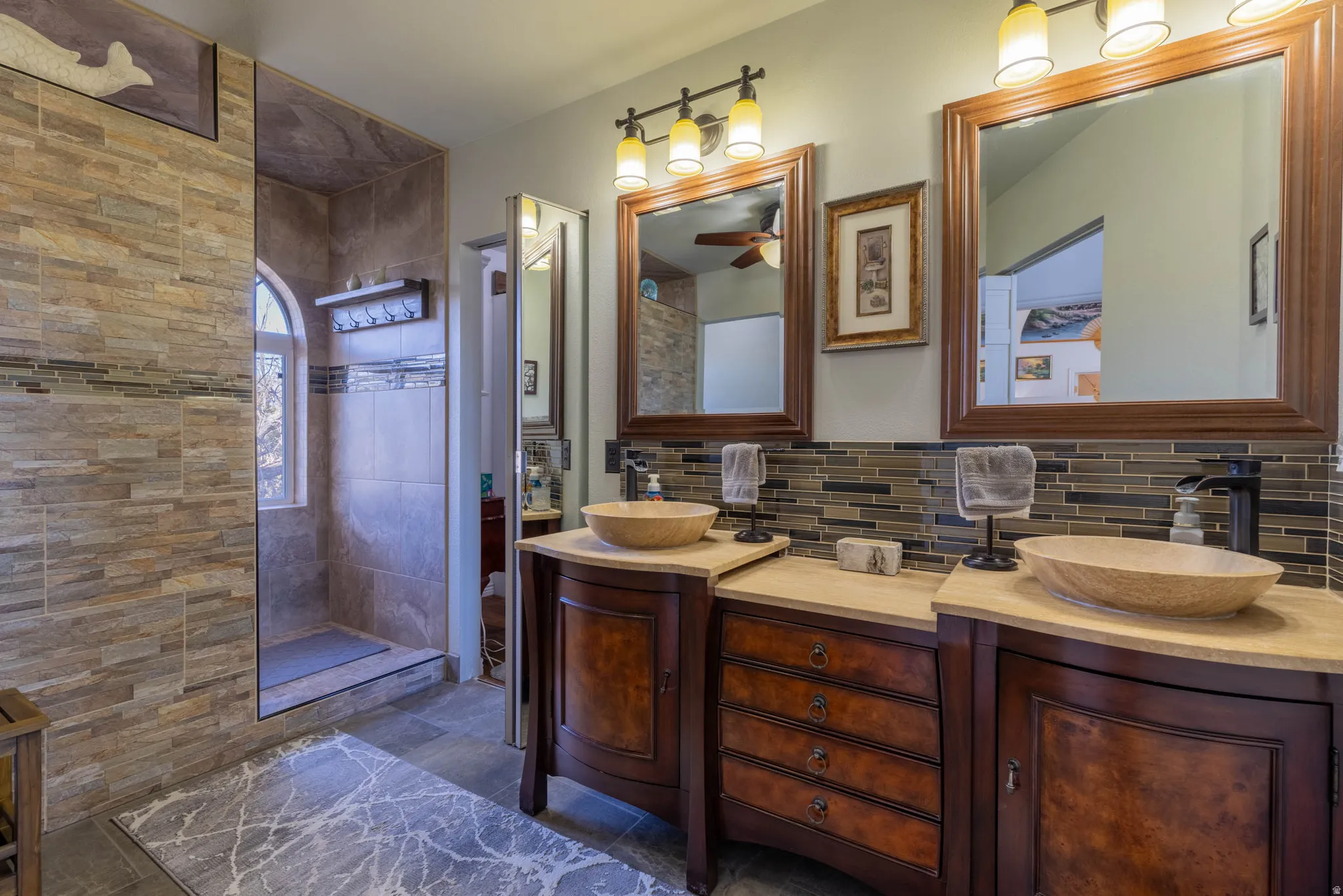 Spa-inspired master bath featuring dual vessel sinks with wood-finish vanity cabinetry, quartz countertops, and oil-rubbed bronze fixtures