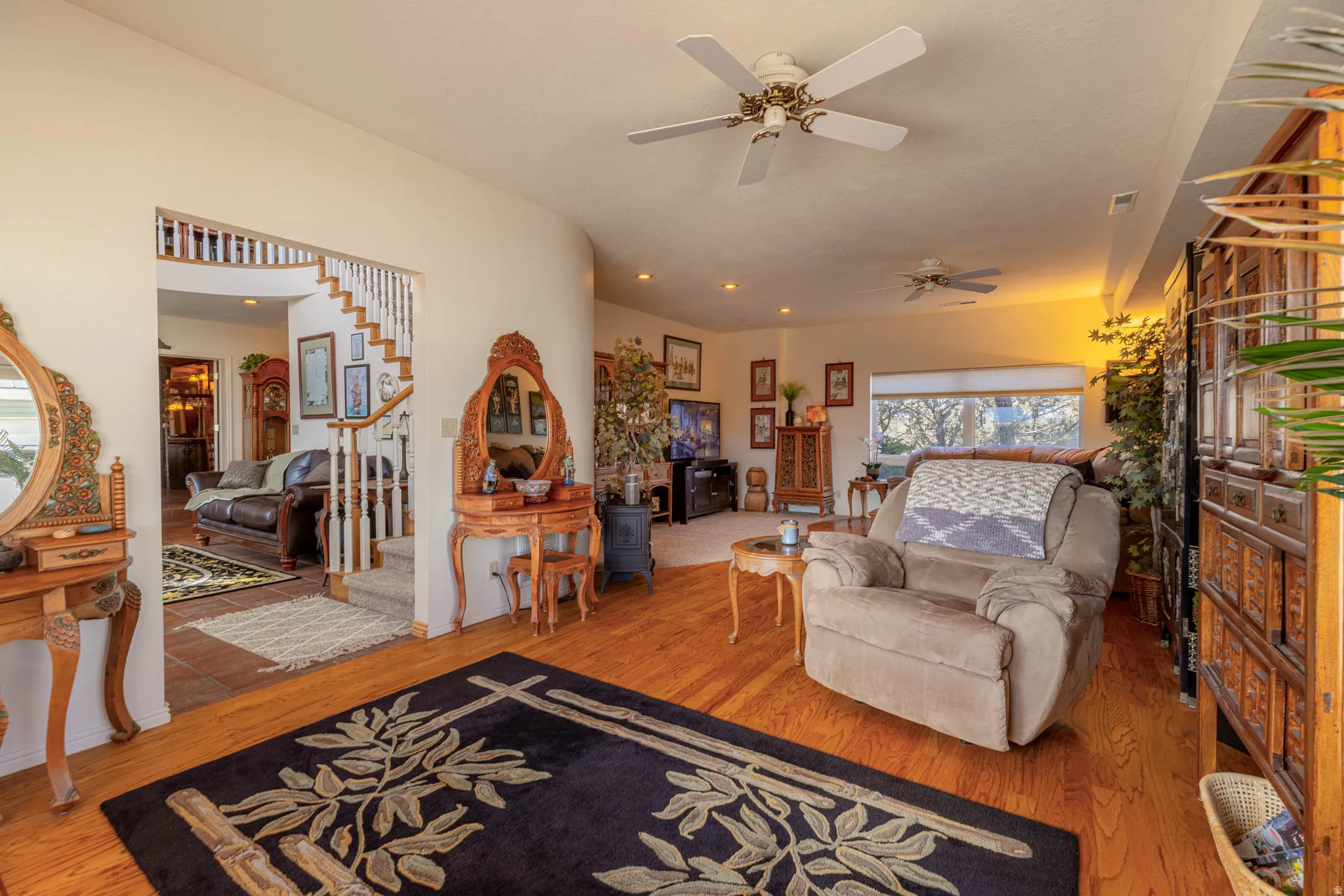 Hardwood flooring throughout, recessed lighting, ceiling fans, and a wide window
