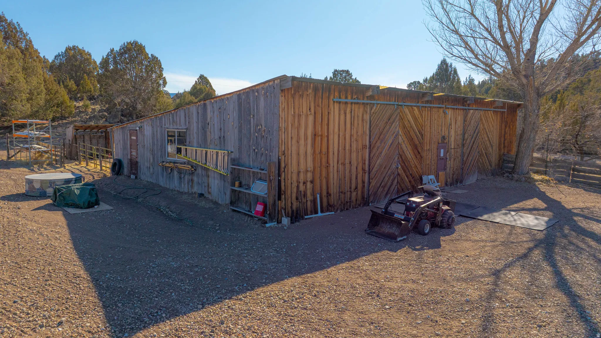 Rustic wood-sided outbuilding with a gravel exterior