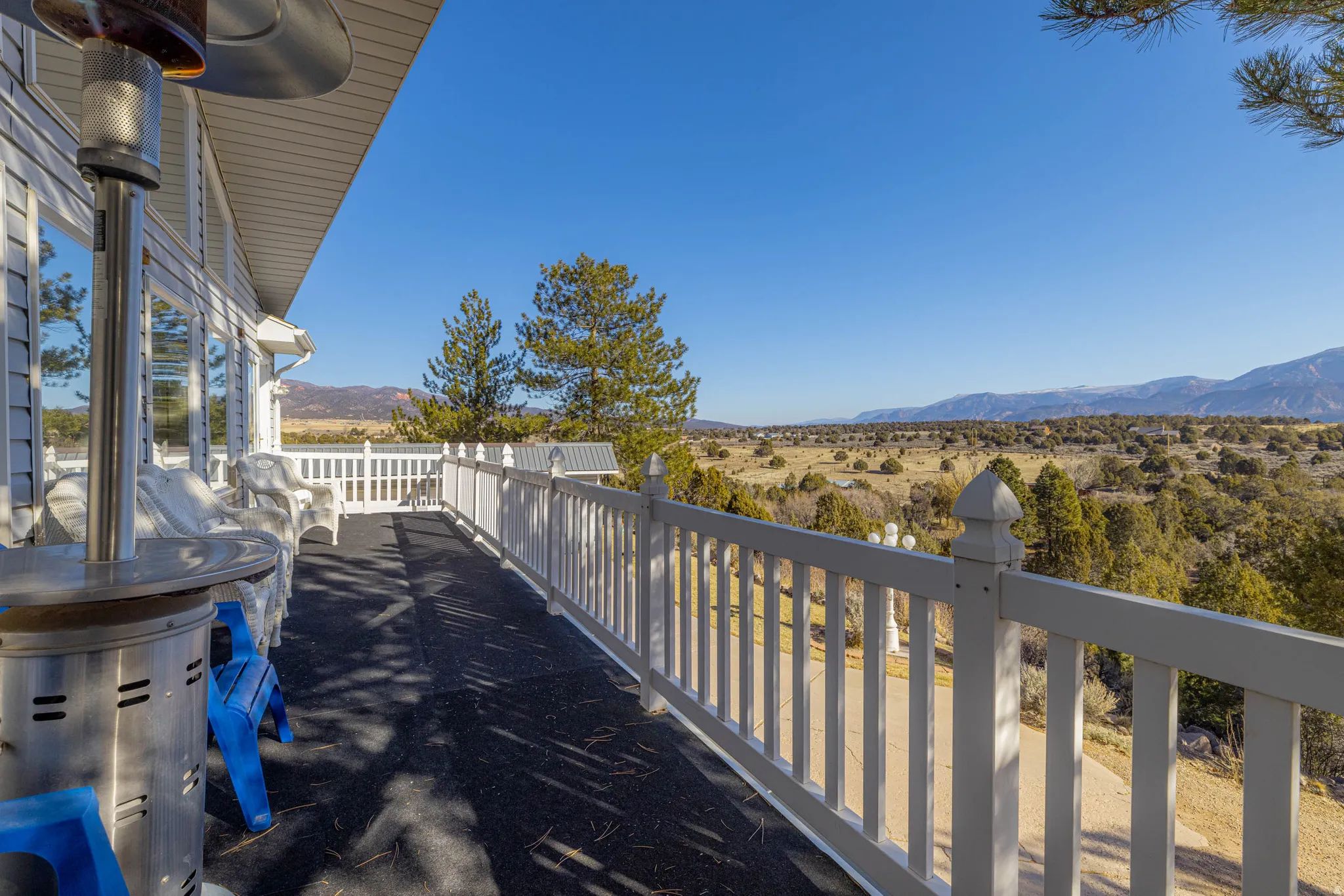 Expansive outdoor deck with white railing, siding exterior, and large windows