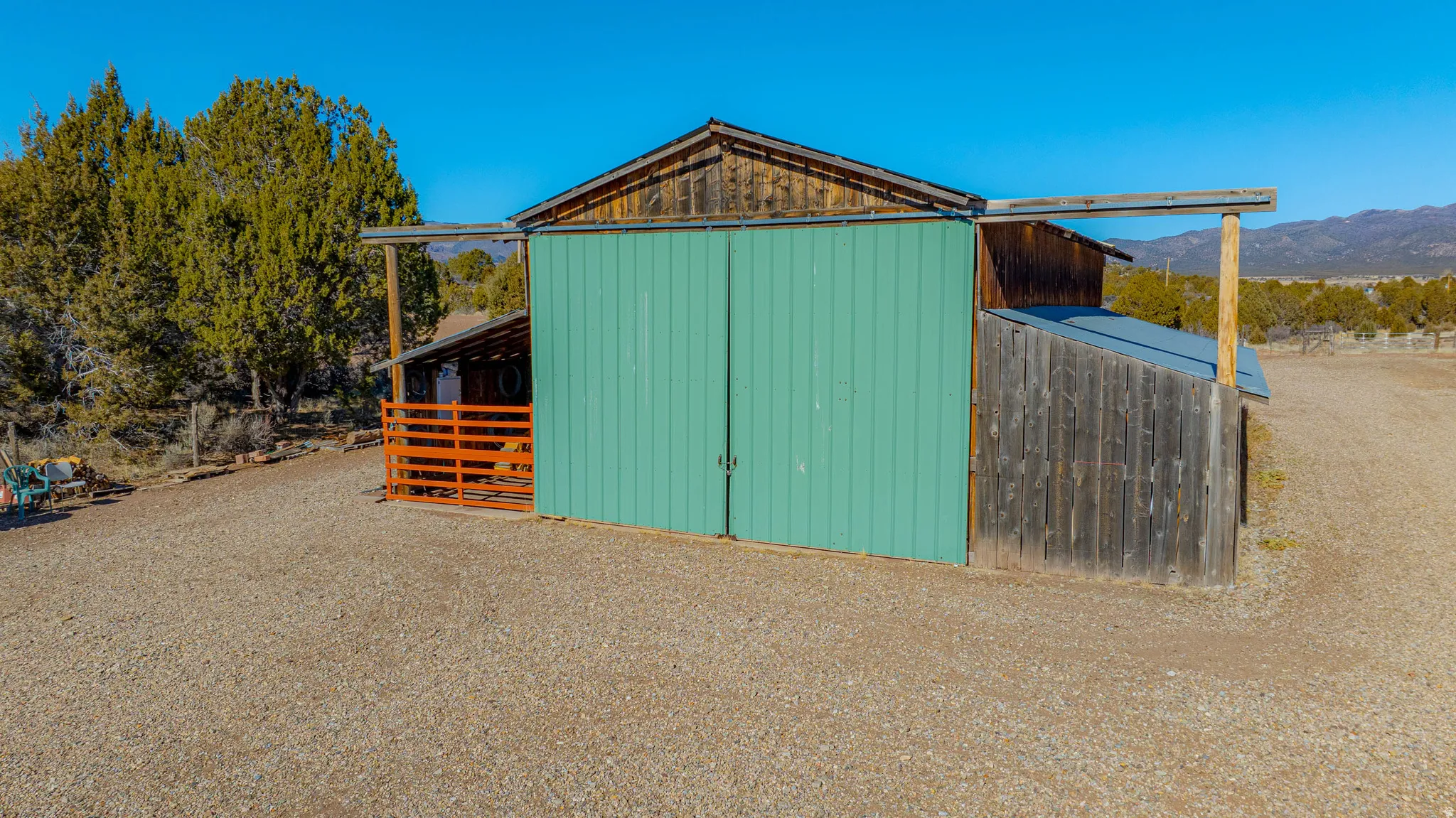 Barn structure featuring wood siding, metal roofing, and a gravel surface