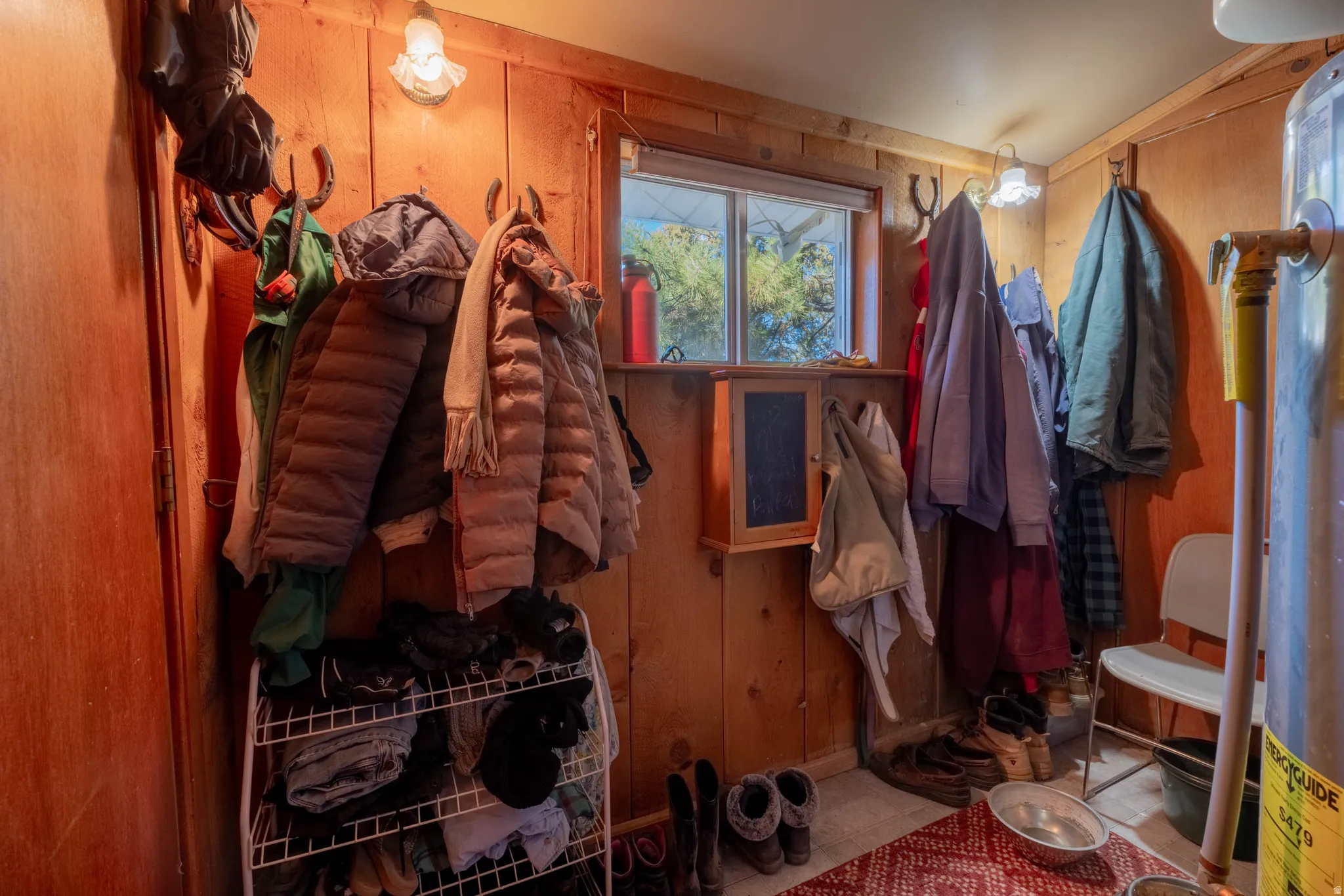 Wood-paneled room featuring a double-hung window and a wall-mounted cabinet