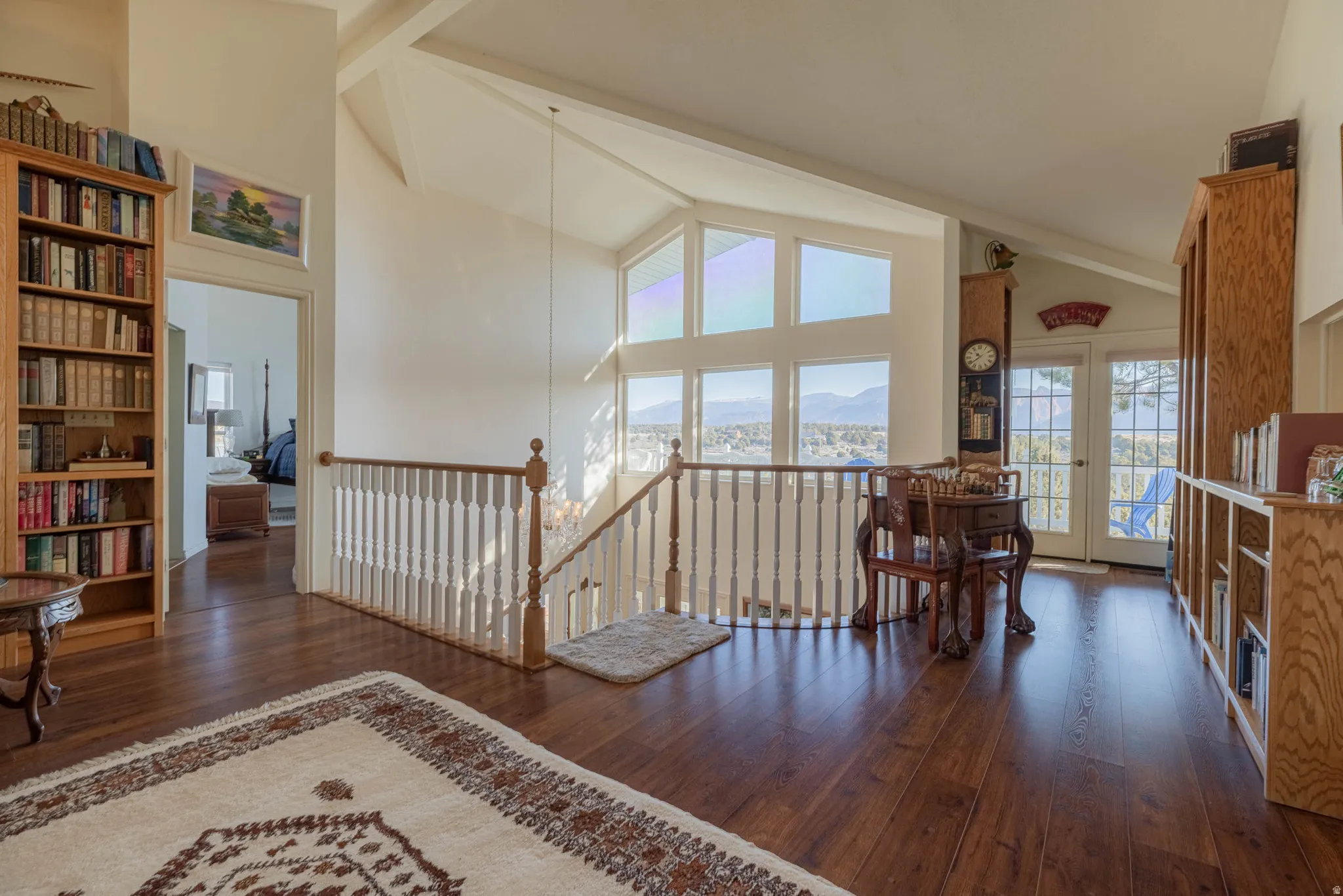Hardwood flooring and a vaulted ceiling complement the white walls