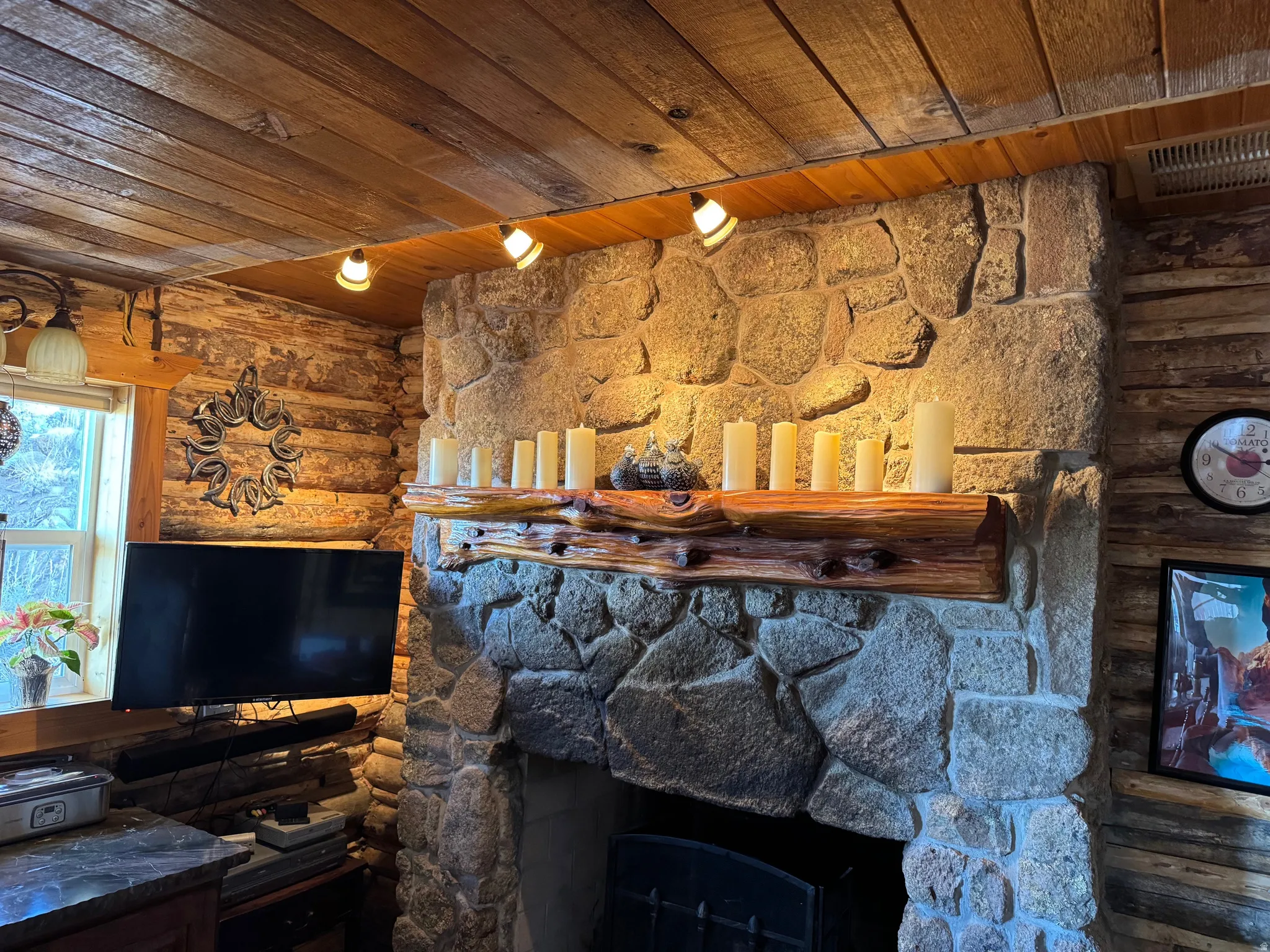 Stone-clad fireplace with a natural wood mantel