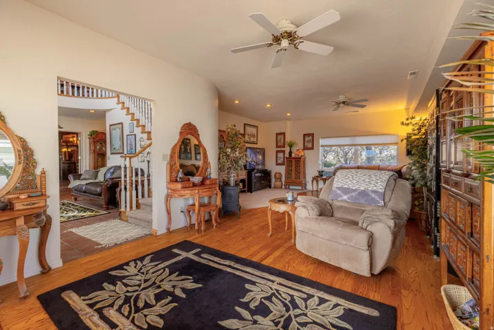 Hardwood flooring throughout, recessed lighting, ceiling fans, and a wide window