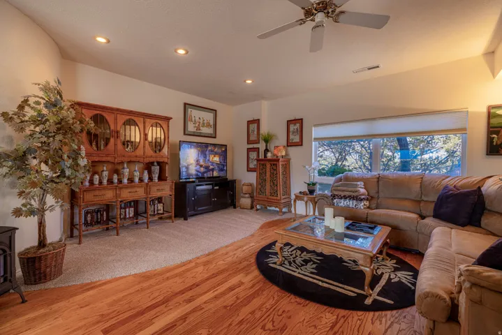 Wood-finish flooring, recessed lighting, and a ceiling fan create a comfortable atmosphere
