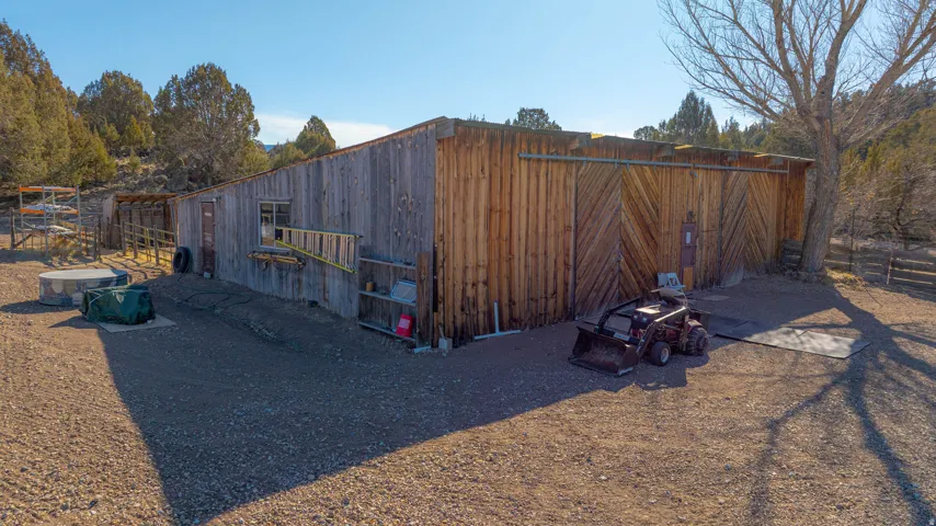Rustic wood-sided outbuilding with a gravel exterior
