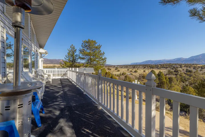 Expansive outdoor deck with white railing, siding exterior, and large windows