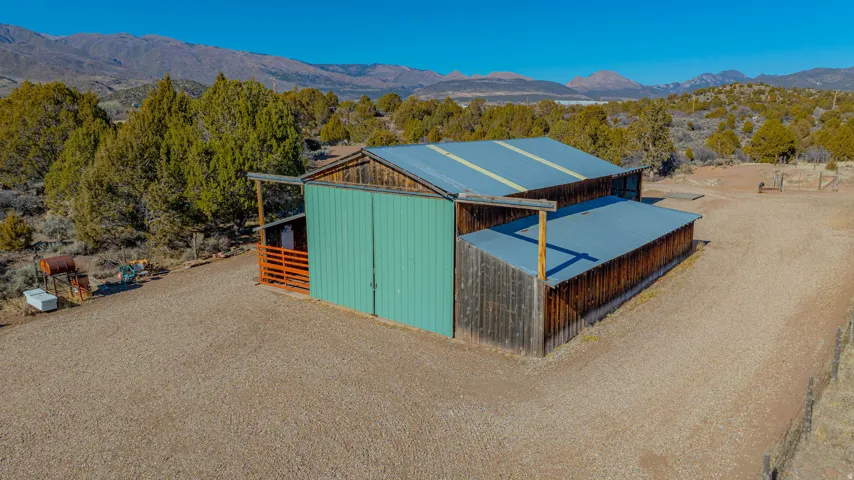 Barn structure with metal roofing, two-tone siding, and an open-sided lean-to