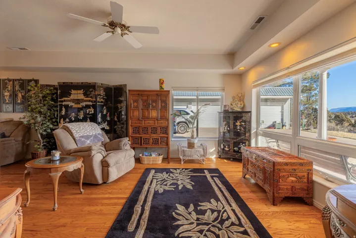 Hardwood-finish flooring, recessed lighting, ceiling fan, and large windows