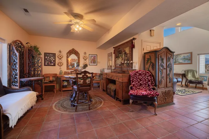 Terracotta-style tile flooring with a recessed ceiling and ceiling fan