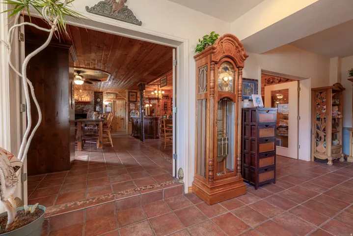 Terracotta tile flooring, double doorway entry, and wood-paneled ceiling