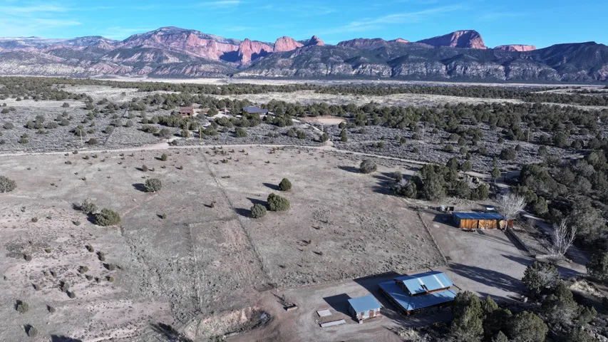 Expansive property with multiple structures, natural landscaping, and a distant mountain backdrop
