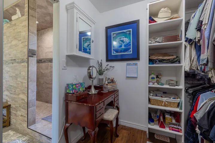 Shower with stone-look tile walls, glass enclosure, and decorative tile accent band