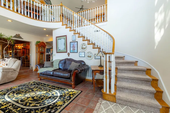 Curved staircase with carpeted treads and wood handrail