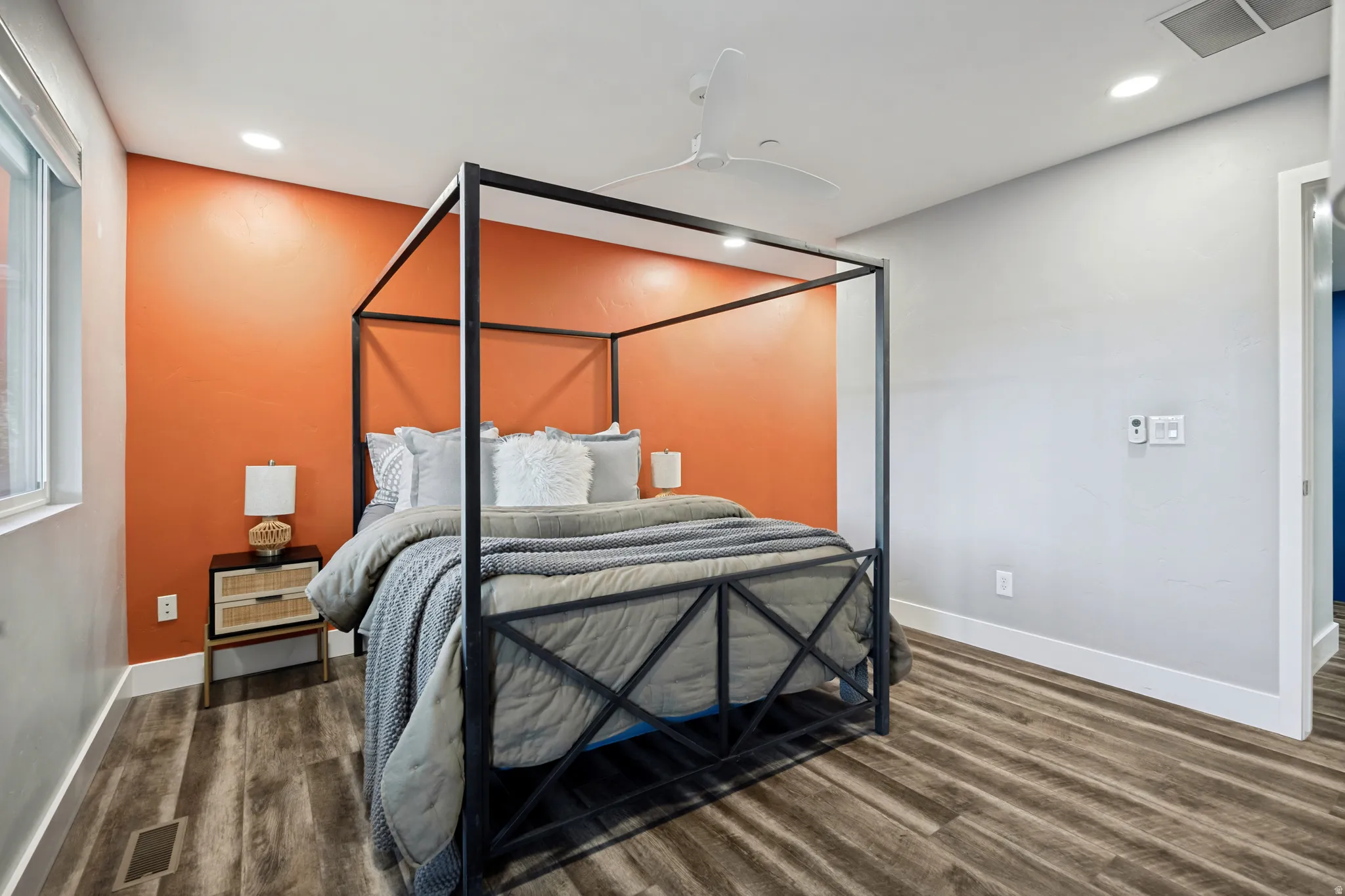 Wood-finish flooring with a textured accent wall, recessed lighting, and a ceiling fan