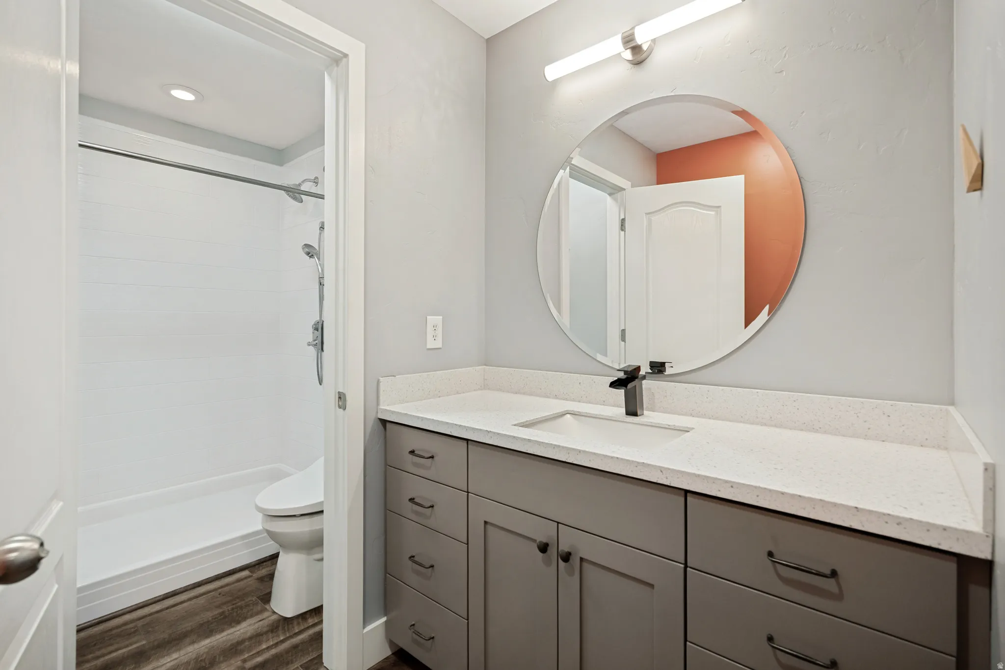 Vanity with a light-toned countertop, integrated sink, and dark-toned hardware