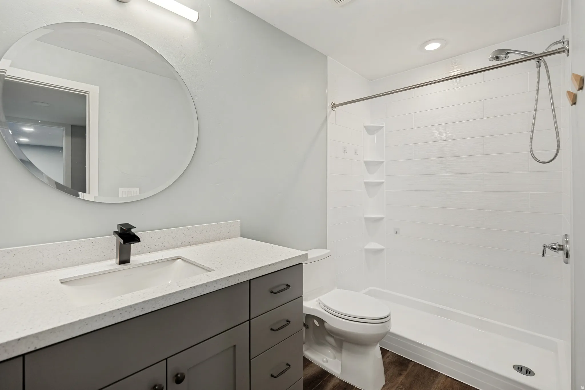 Bathroom featuring a spacious vanity with a white countertop and a dark gray cabinet