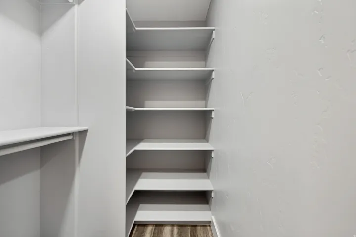 Built-in shelving, hanging rod, and wood-finish flooring
