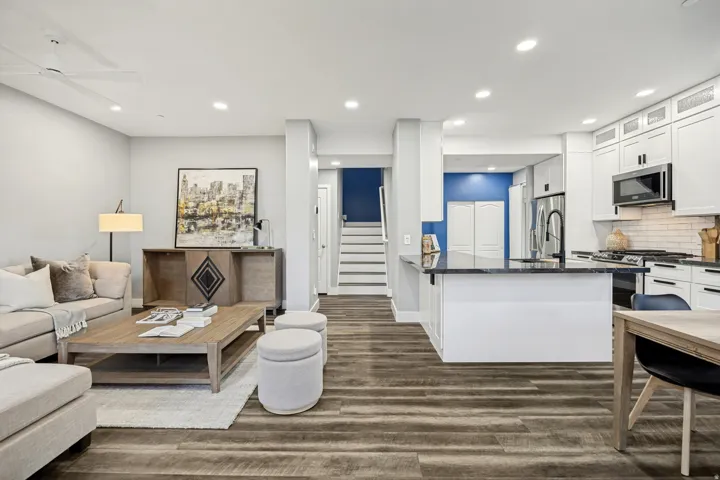 Open-concept living area with wood-finish flooring, recessed lighting, and a ceiling fan