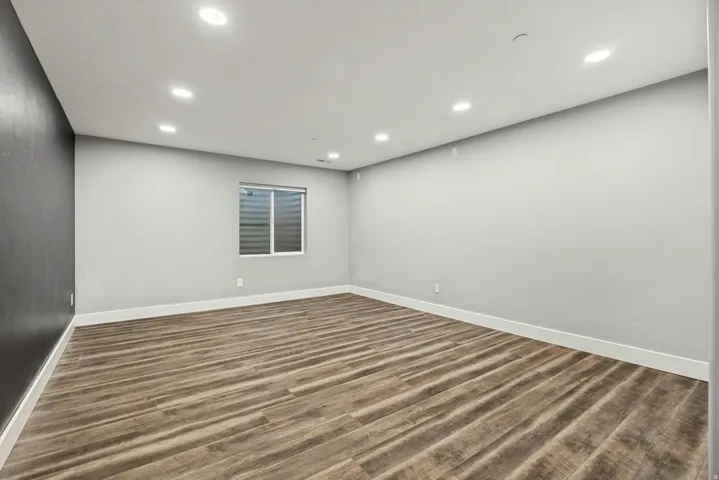 Recessed lighting illuminates wood-finish flooring