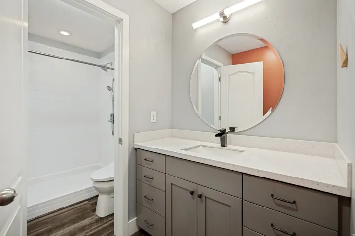 Vanity with a light-toned countertop, integrated sink, and dark-toned hardware