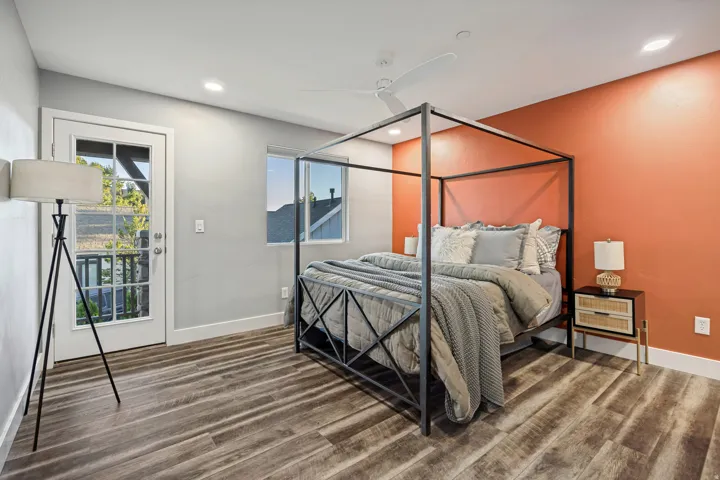 Wood-finish flooring, a ceiling fan, recessed lighting, and a window providing natural illumination