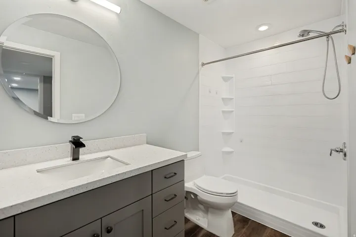 Bathroom featuring a spacious vanity with a white countertop and a dark gray cabinet