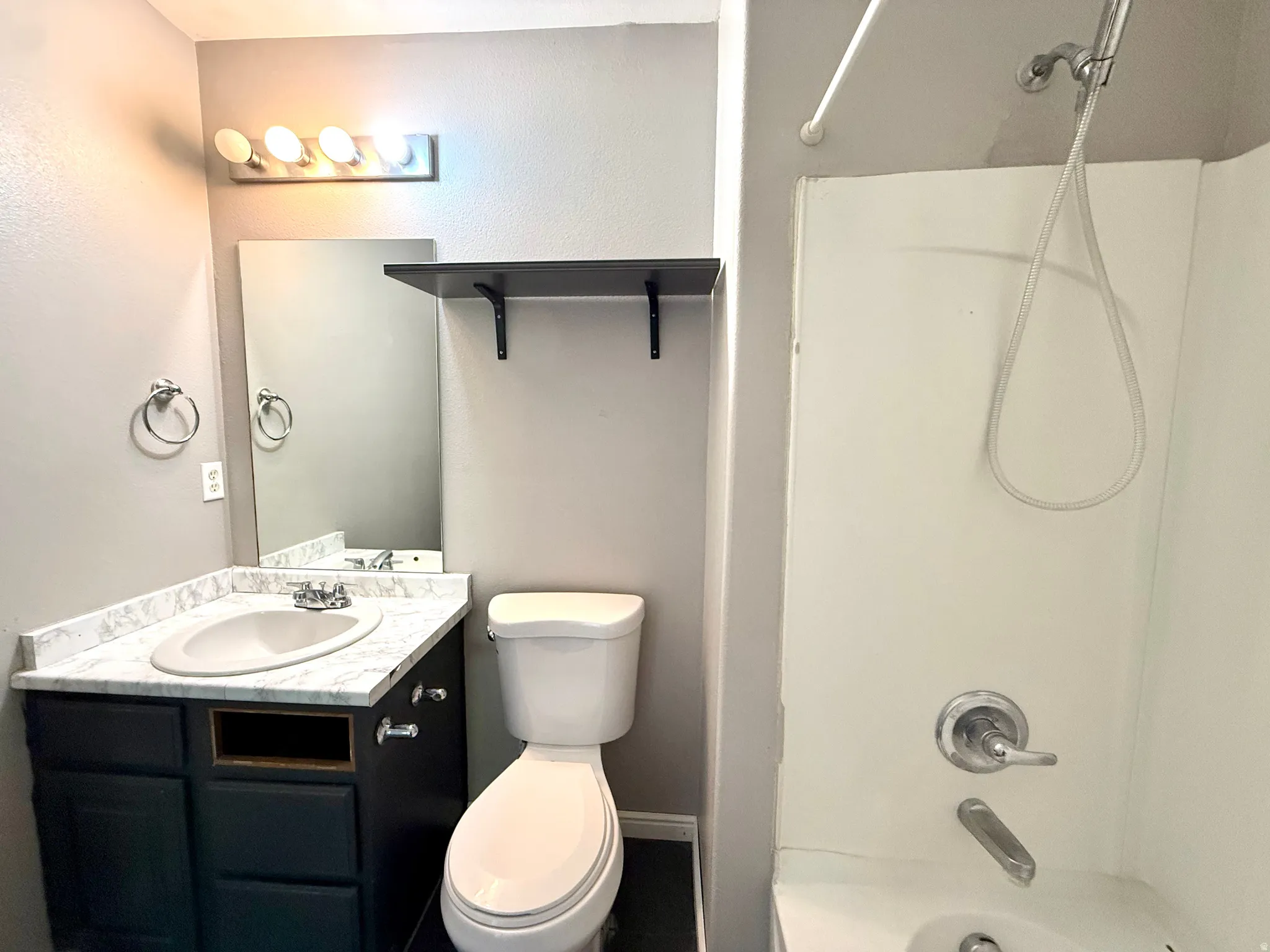 Vanity with a white countertop and integrated sink, chrome faucet, and dark base
