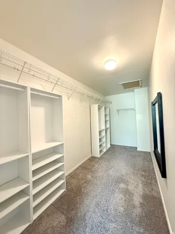 White built-in shelving, wire shelving, and neutral carpeting