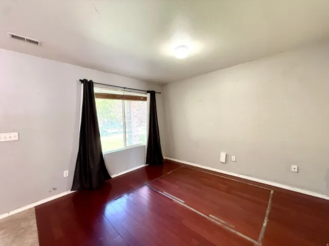 Room featuring wood-finish flooring and a flush-mount ceiling light