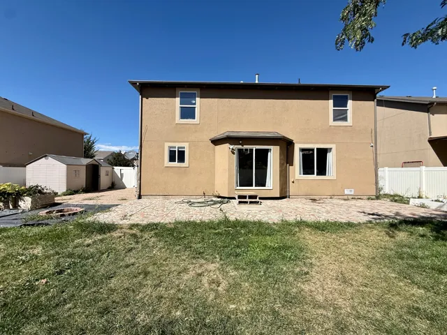 Stucco exterior with multiple windows and a sliding glass door