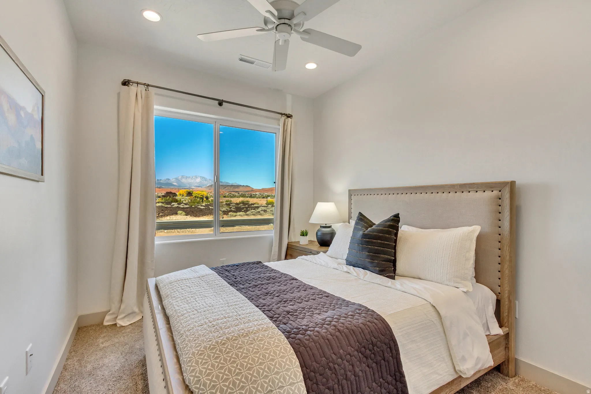 Recessed lighting, ceiling fan, large window, broad scenery, and carpeted flooring
