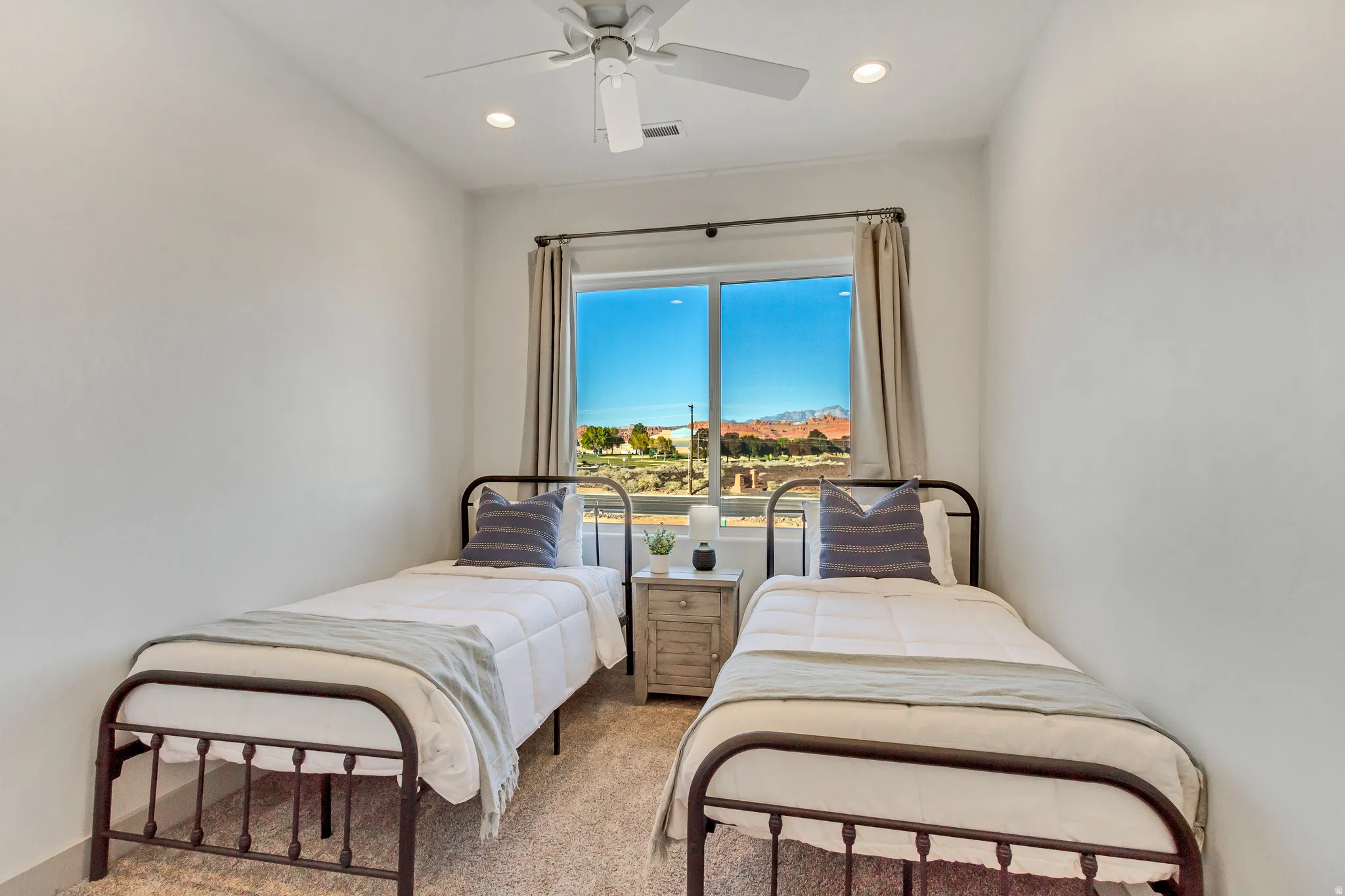 Recessed lighting, ceiling fan, and large window with natural light