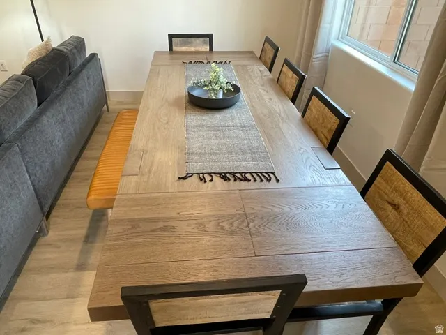 Spacious dining area featuring wood-finish flooring, a large window, and recessed lighting