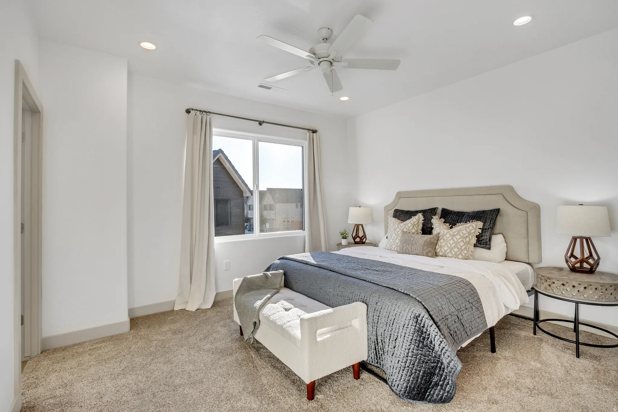Wall-to-wall carpeting, recessed ceiling lighting, a ceiling fan, and a light-filled window