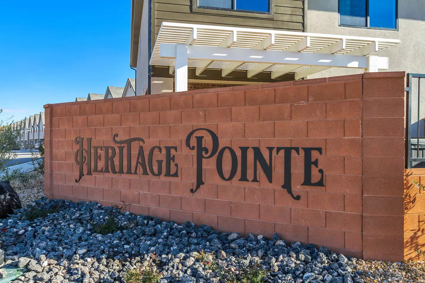 Brown brick entry wall featuring "Heritage Pointe" lettering